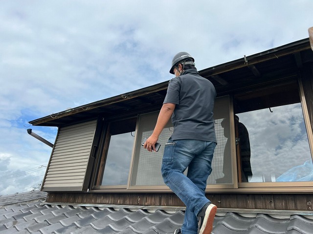 屋根に登って雨樋調査を行う様子